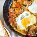 ratatouille with poached eggs in a black pan