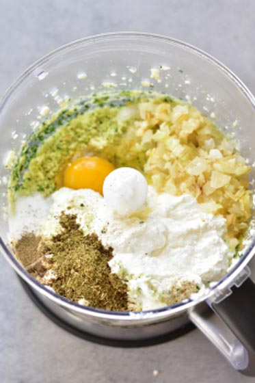 egg, ricotta cheese, sauteed onion and herbs in a food processor bowl