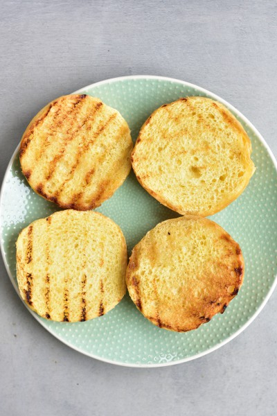 toasted brioche hamburgers buns on a green plate