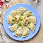 Sauerkraut and mushroom pierogi on a blue plate.