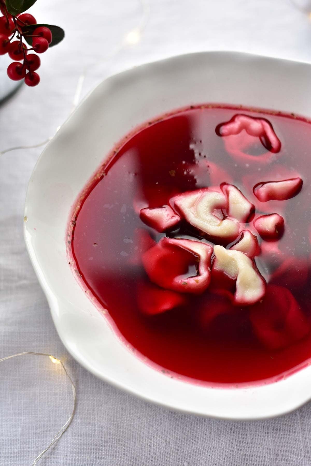 Polish Christmas eve borscht with small dumplings in a white bowl.