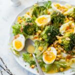 broccoli egg salad with honey mustard dressing on a white plate