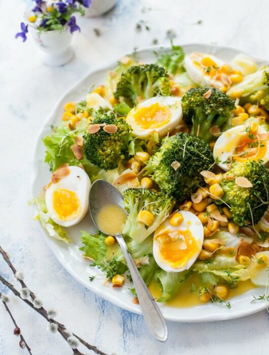 broccoli egg salad with honey mustard dressing on a white plate