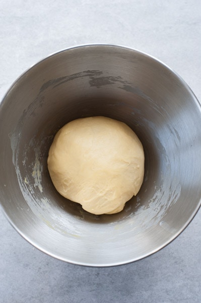 Kneaded yeast dough for the easter bunny rolls in a metal bowl