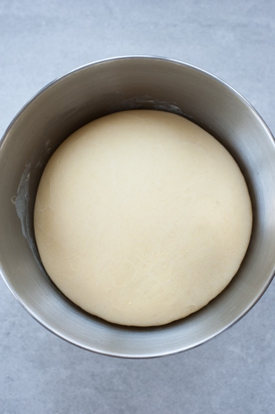 Risen yeast dough in a metal bowl