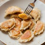 vegan pierogi with lentil and sun-dried tomato filing on a light brown plate