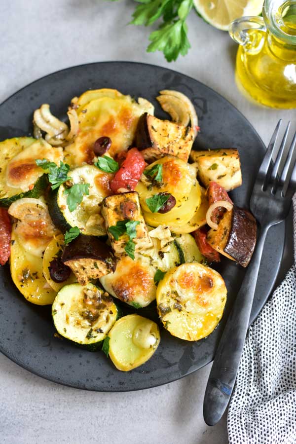 close up photo on briami greek style oven roasted vegetables casserole on a black plate