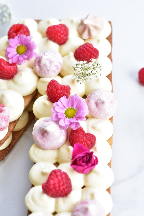 A close up photo of number cake - lemon cream tart with raspberries.