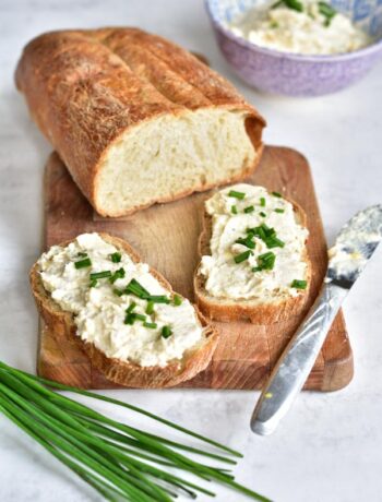 smoked trout spread on a piece of bread on a wooden board