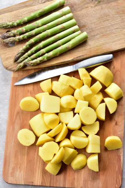 trimmed asparagus and cut potatoes on a chopping board
