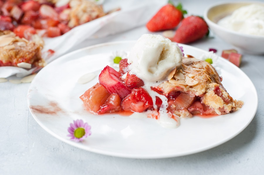 a piece of strawberry rhubarb galette on a white plate