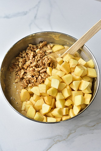 cubed apples and chopped walnuts in a metal bowl