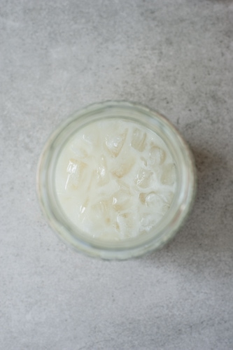 pina colada ingredients with crushed ice in a jar