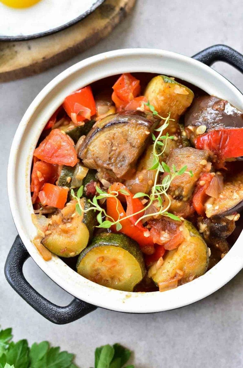 A close up picture of ratatouille in a black pot.