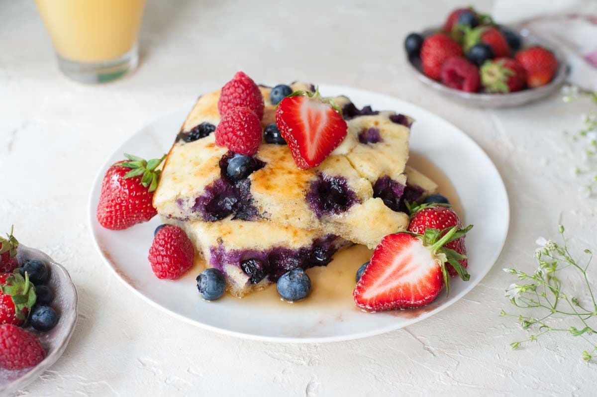 sheet pan pancakes on a plate with fresh berries