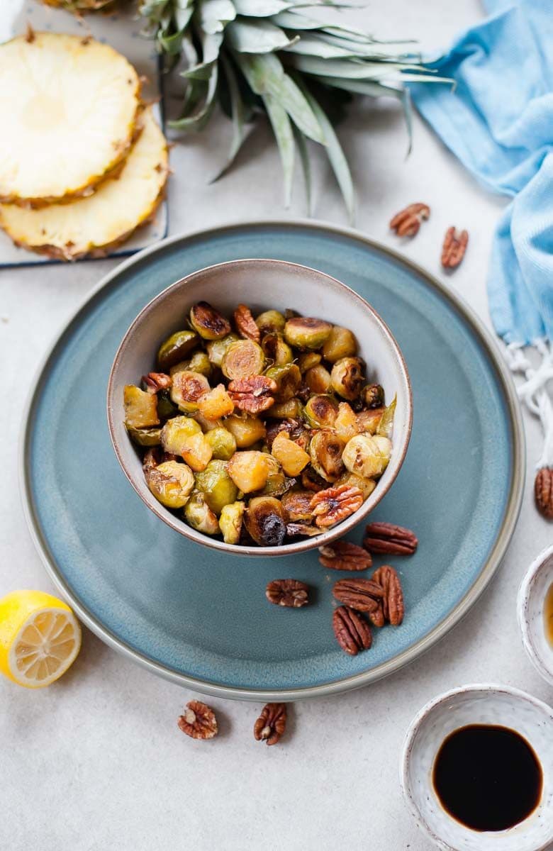 roasted brussel sprouts with pineapple and pecans in a bowl