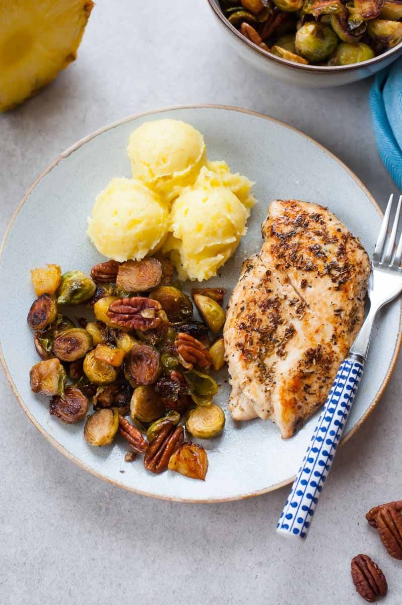 roasted brussel sprouts, mashed potatoes and pan-fried chicken breast on a plate