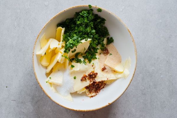 ingredients for herb and chili butter in a white bowl