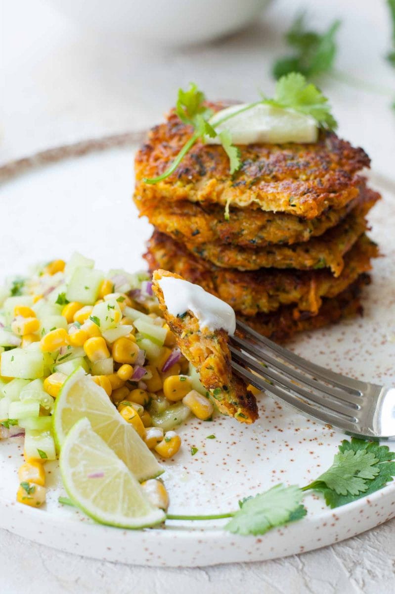 close up shot on sweet potato and zucchini fritters with cucumber corn salsa
