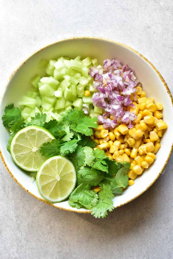 cucumber corn salsa ingredients in a white bowl