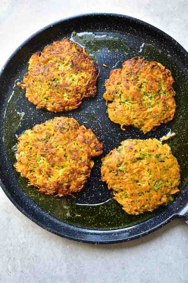 sweet potato zucchini fritters are being cooked on a pan