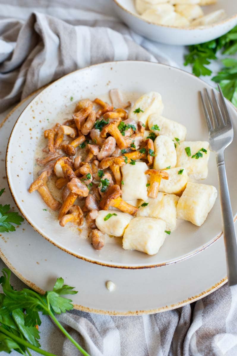 Ricotta gnocchi with chanterelle sauce in a brown bowl.