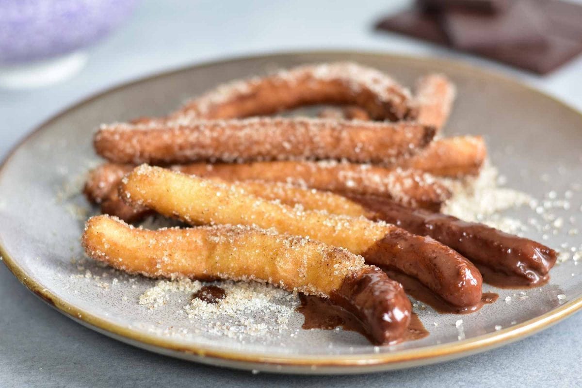 Churros with chocolate sauce on a plate