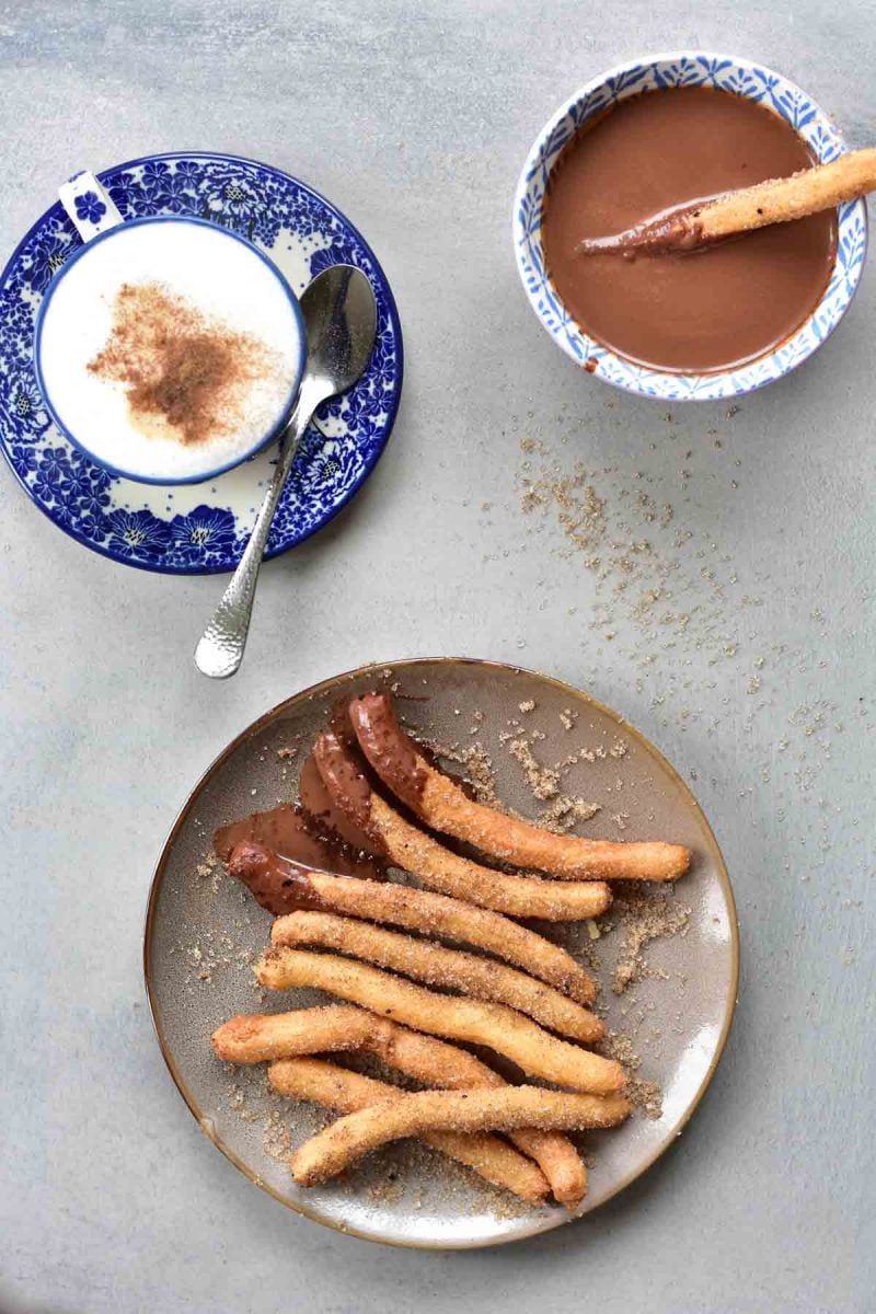 overhead view on churros with chocolate sauce on a plate