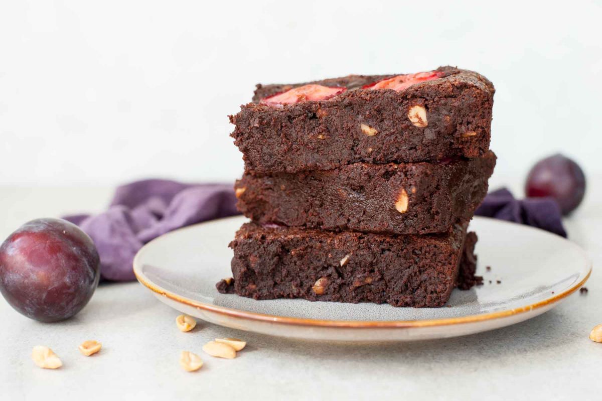 3 servings of Brownie with peanuts and plums on a plate