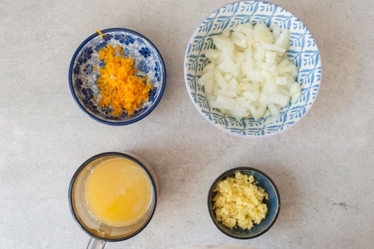 chopped onion, grated ginger and orange zest, orange juice in small bowls