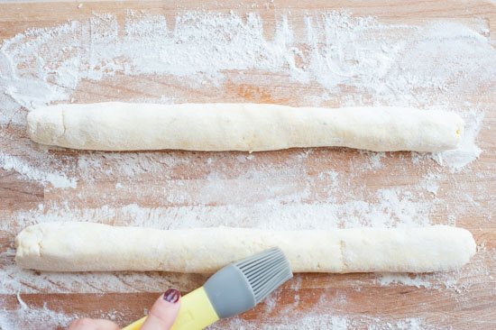excess flour is being brushed off from ricotta gnocchi dough