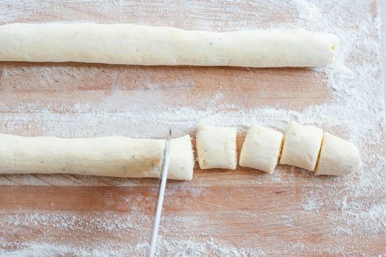 ricotta gnocchi dough is being cut into portions