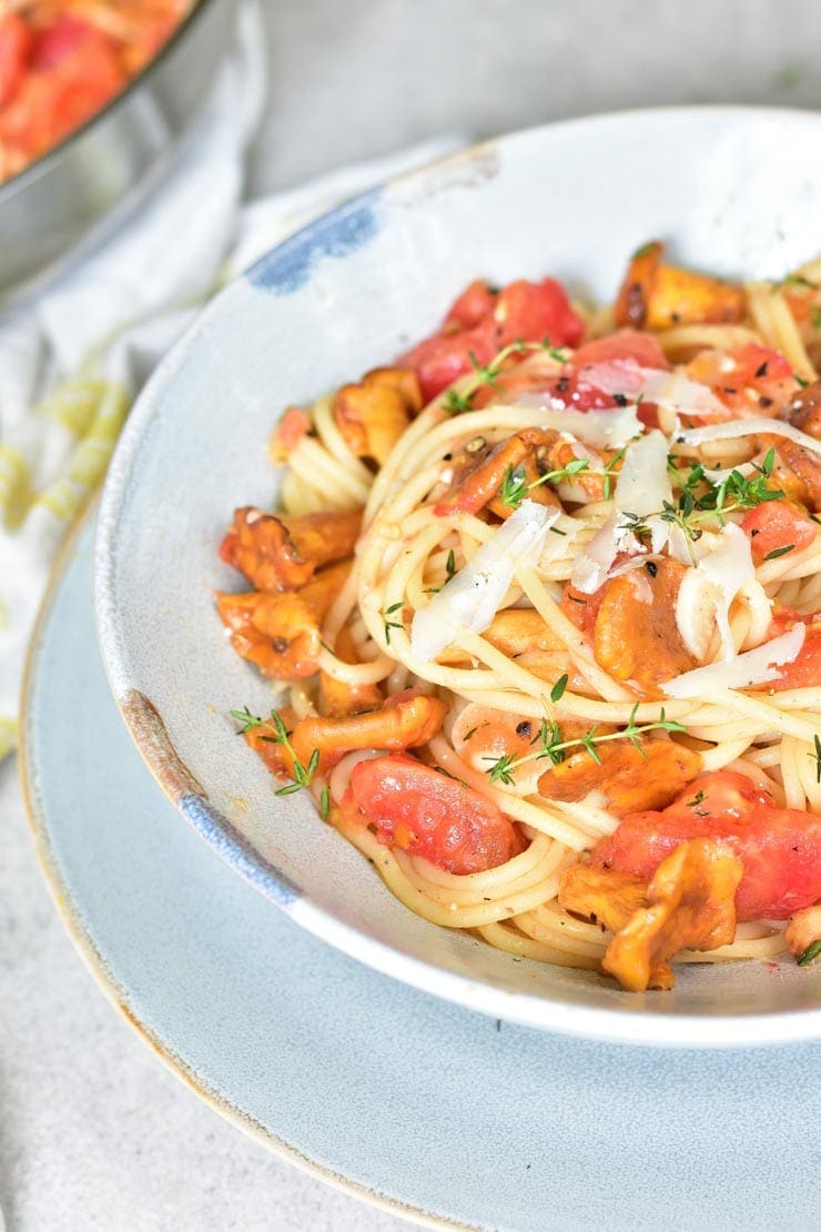 close up picture of spaghetti with chanterelles and tomatoes