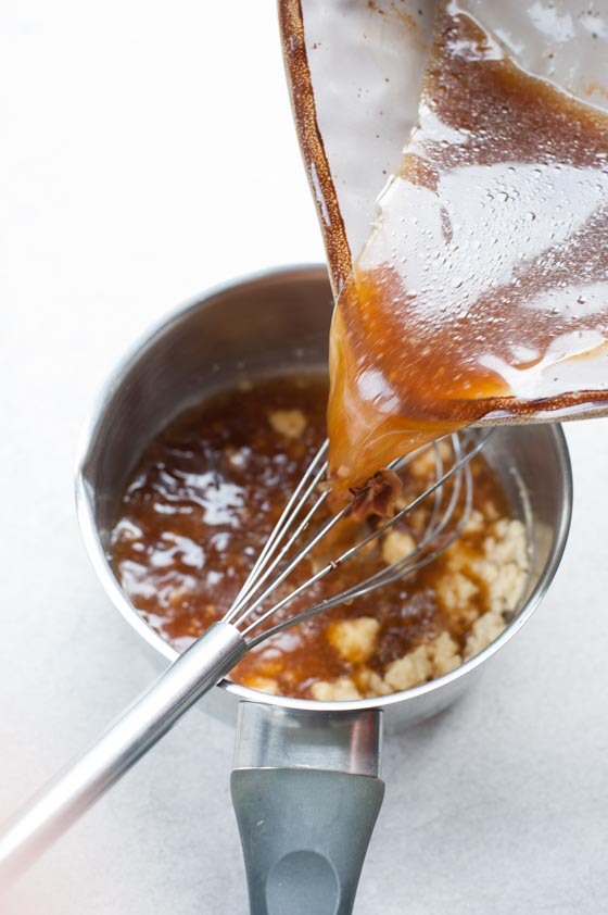 the content of a baking dish is being poured into a small pot