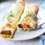 vegetable crepes on a blue plate sprinkled with fresh thyme leaves