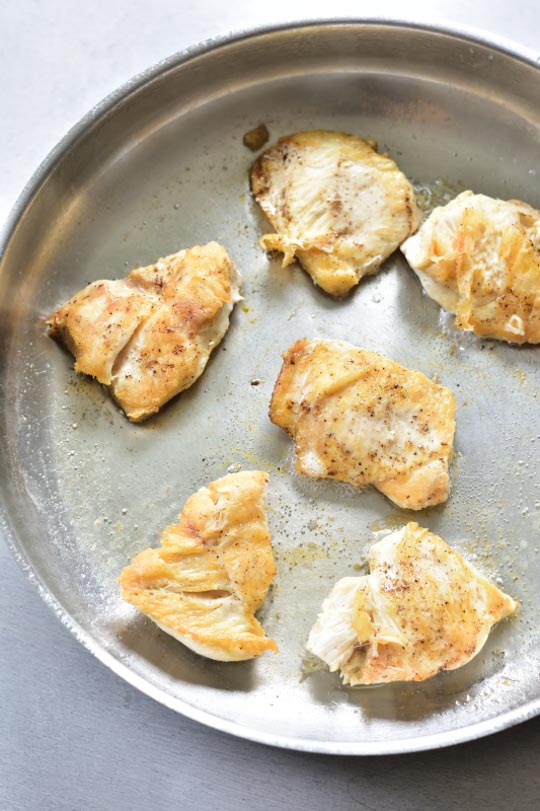 chicken pieces are being pan-fried