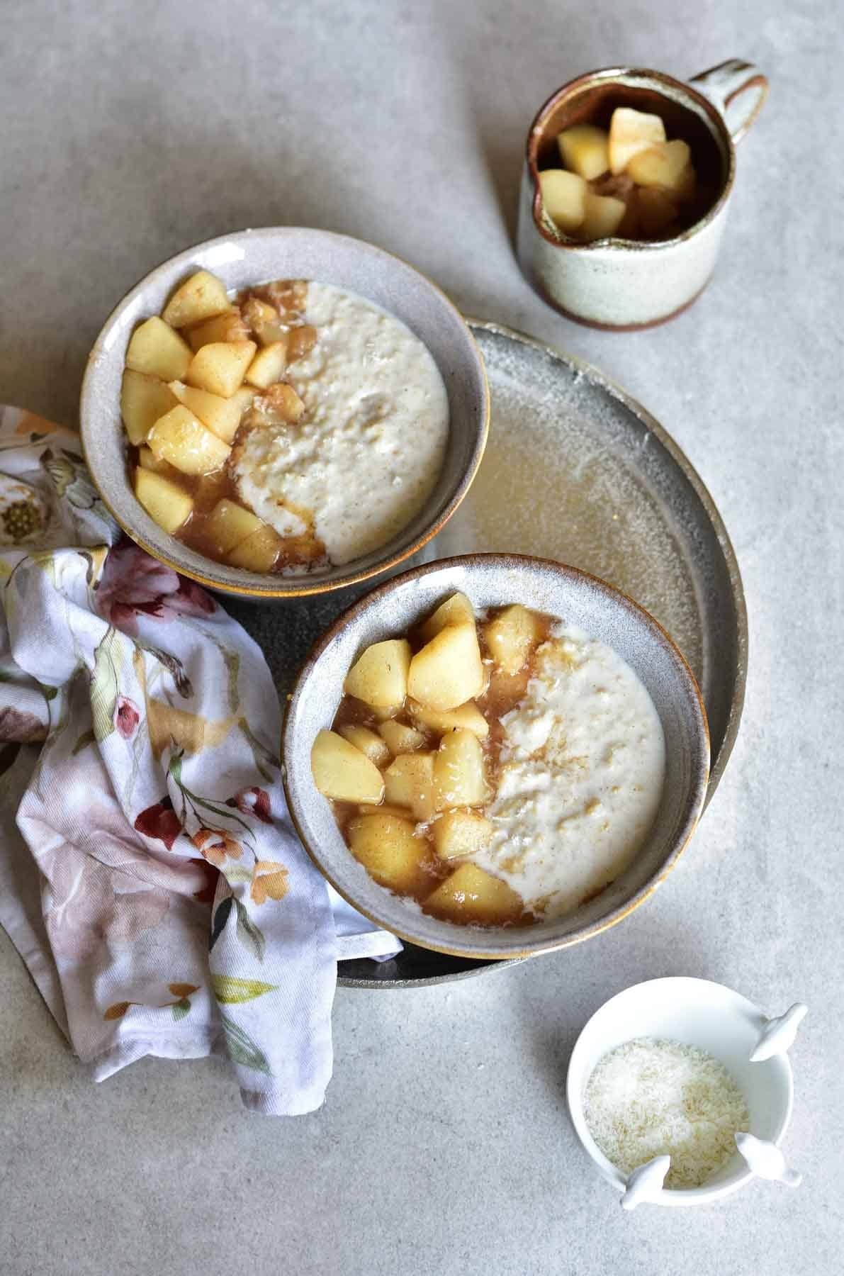 two bowls with creamy coconut oatmeal with spiced pears