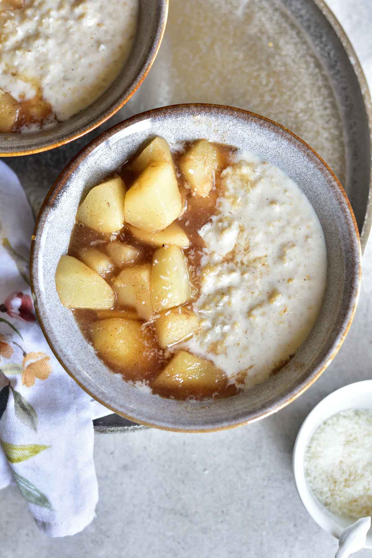 Coconut oatmeal with syrupy pears in a grey bowl.