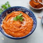 romesco sauce in a blue bowl, parsley on top