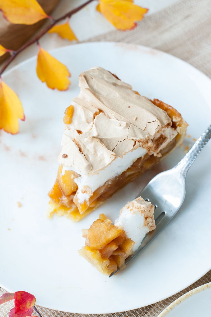 overhead shot on apple tart with meringue topping on a plate and a fork