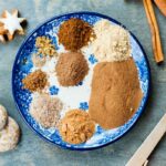 ingredients for gingerbread spice mix on a white-blue plate