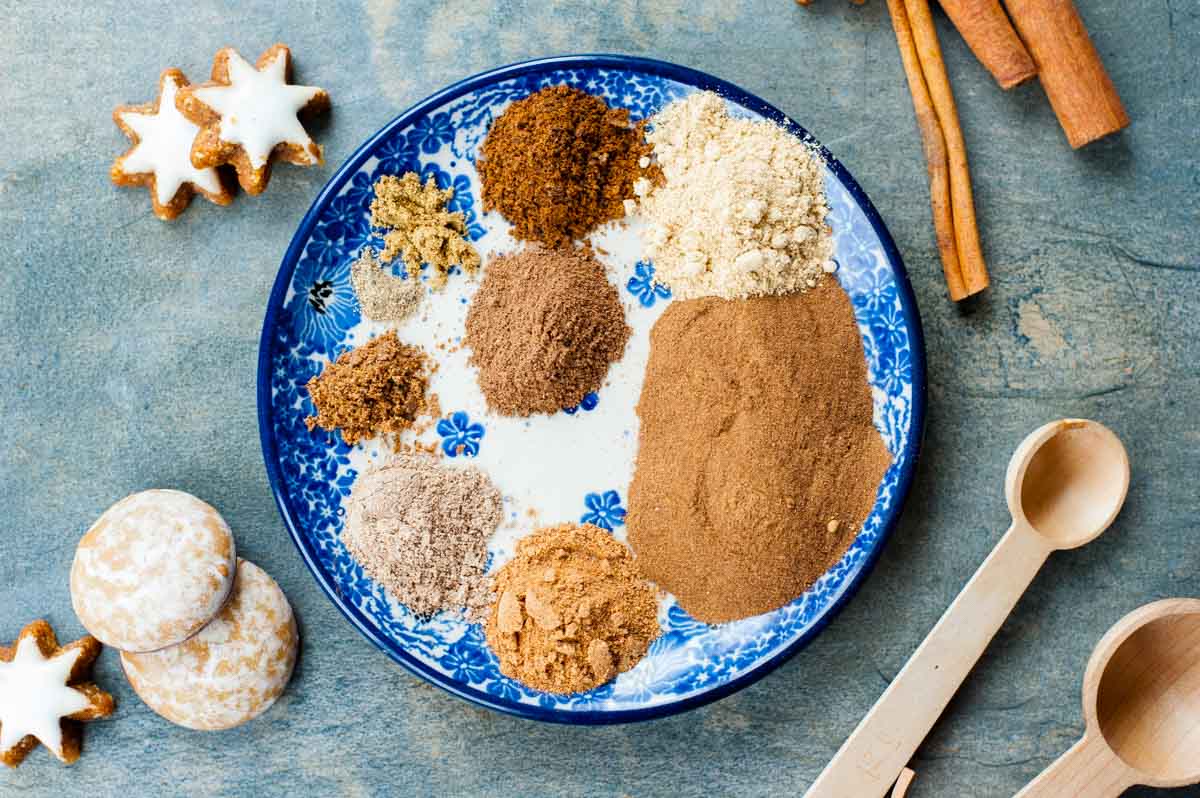 Ingredients for gingerbread spice mix on a white-blue plate.