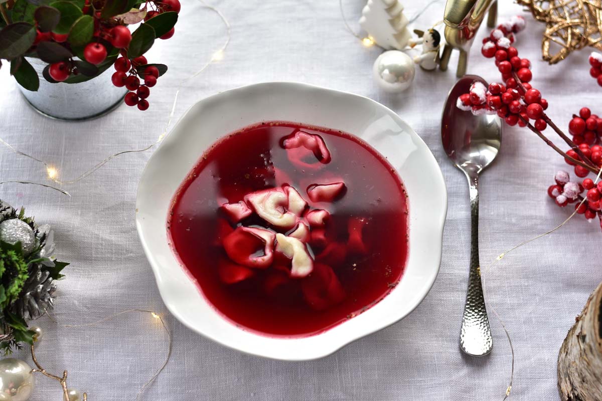 Polish Christmas Eve Beet Soup Recipe on a table surrounded with Christmas decorations.