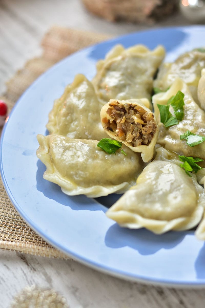 Sauerkraut and mushroom pierogi on a blue plate.