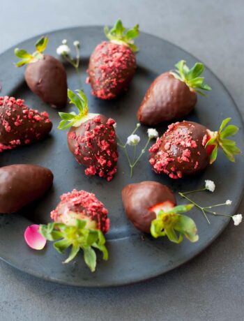 chocolate covered strawberries on a black plate