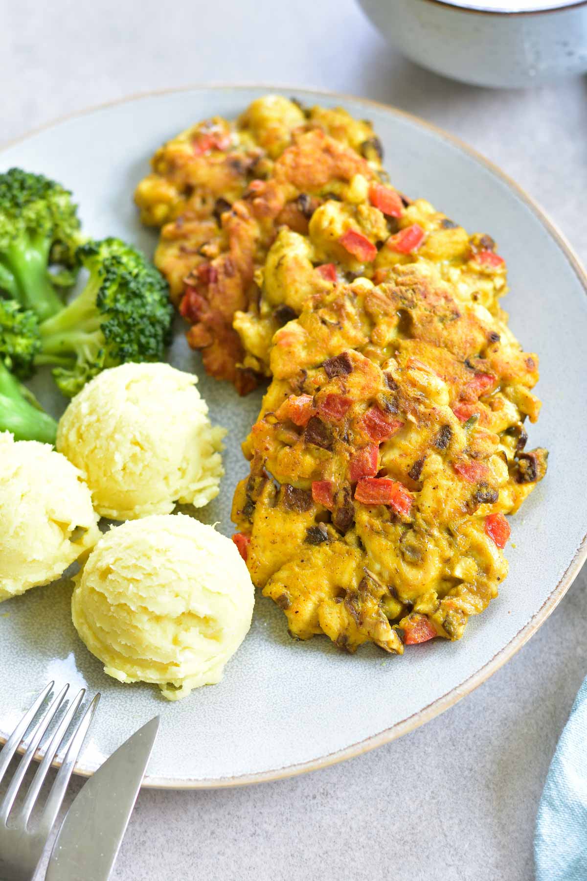 curried chicken fritters with cremini mushrooms and bell paprika on a blue plate