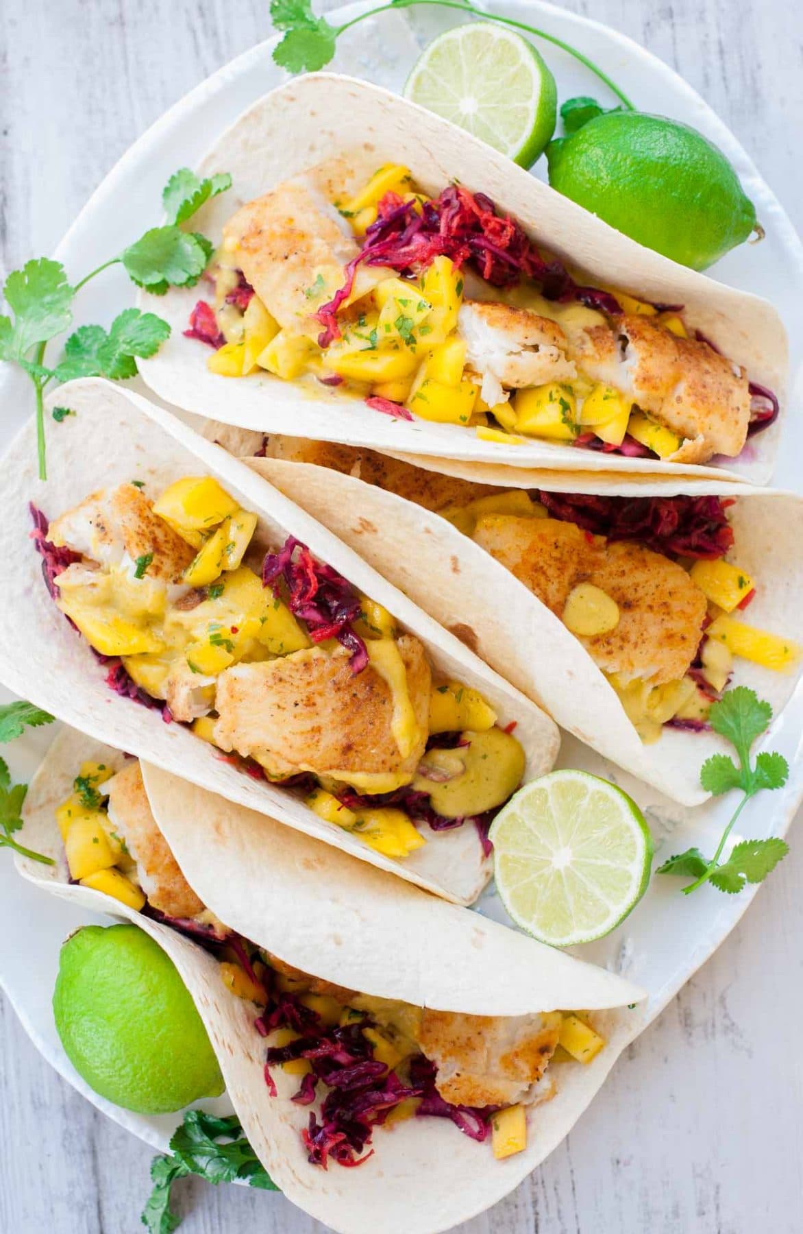Fish tacos with mango salsa, mango sauce and red cabbage carrot slaw.