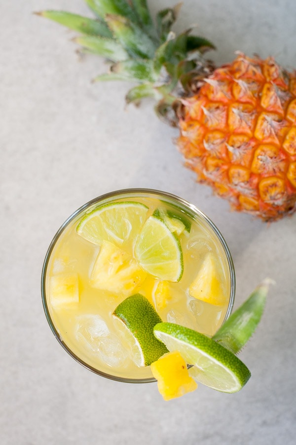 Pineapple caipirinha in a glass. Pineapple in the background.