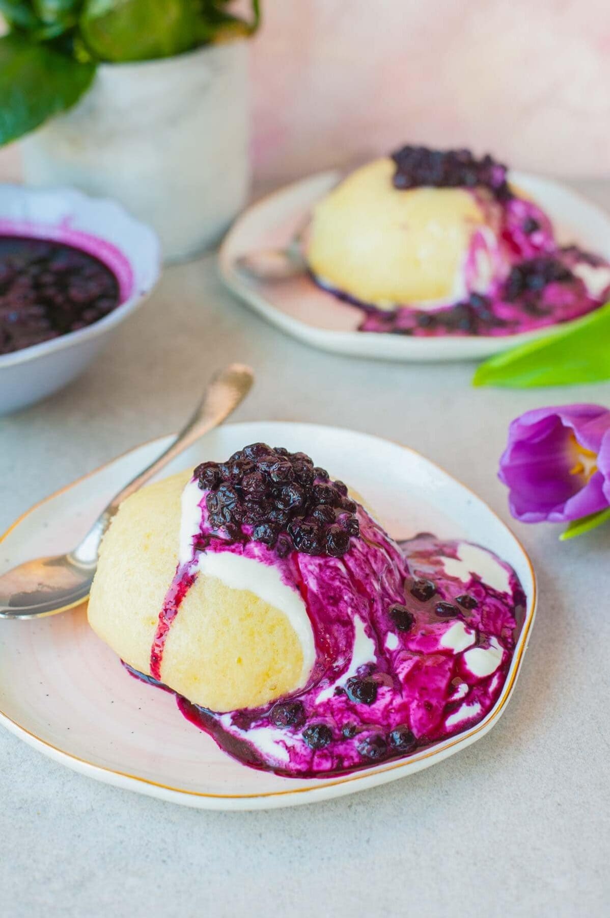 Fluffy sweet steamed buns with blueberry sauce on a rose plate