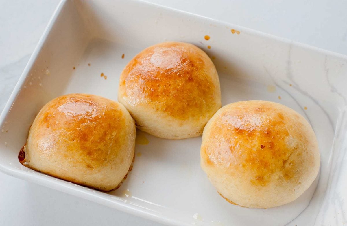 Baked buns in a white baking dish.
